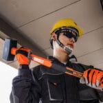 Person wearing Wokin Safety Helmet and gloves while holding a sledgehammer