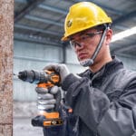 Person wearing Wokin Safety Helmet and while drilling with a cordless drill