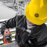 Person wearing Wokin Safety Helmet while using a drill on a construction site