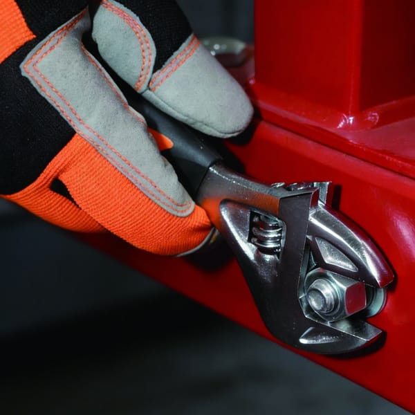 Side view of a WOKIN stubby adjustable wrench being used for industrial repair work.
