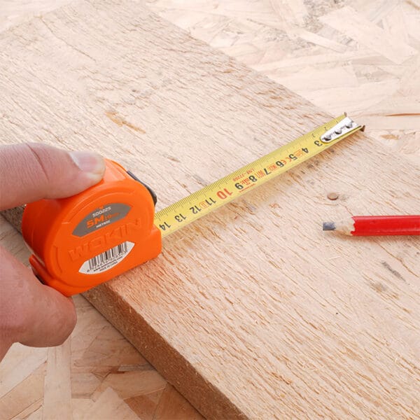 Using a measuring tape from the Wokin 98pcs tool chest set to measure a wooden board