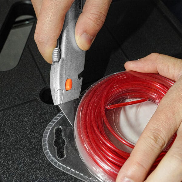 Using a utility knife from the Wokin 98pcs tool chest set to cut the packing of red wire