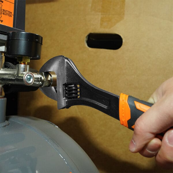Using an adjustable wrench from the Wokin 98pcs tool chest set on an air compressor valve