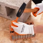 Using a hammer and a chisel from the Wokin 163pcs roller cabinet tools set on a brick