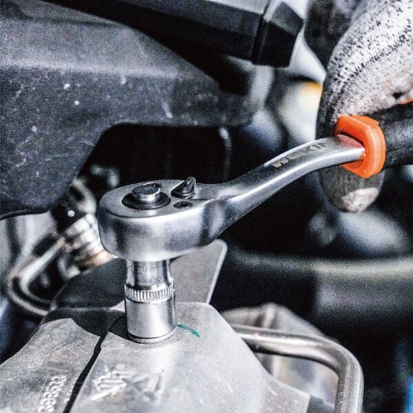 Close-up of WOKIN ratchet wrench and socket being used on a vehicle part