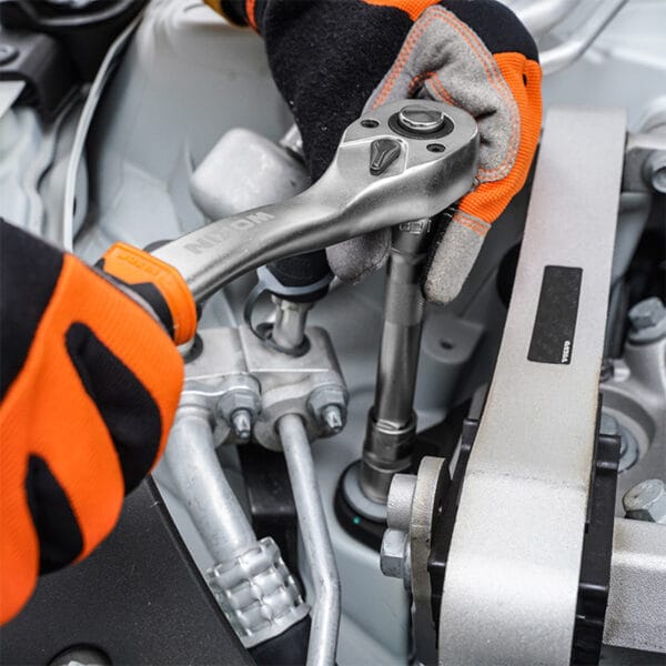 Close-up of two hands wearing WOKIN work gloves using WOKIN ratchet wrench tighten car engine component