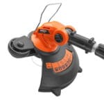 Detail view of the cutting head showing the flower guard wire and the guide wheel for vertical lawn edging.