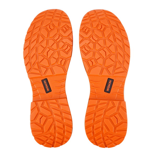 Bottom view showing the bright orange, slip-resistant rubber outsoles of the WOKIN safety shoes, featuring an aggressive tread pattern for maximum traction on work sites.